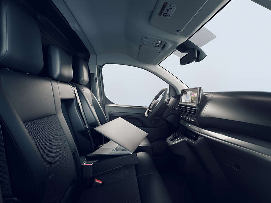 Вид інтер’єру нового Opel Vivaro з пасажирських дверей з ноутбуком на сидінні